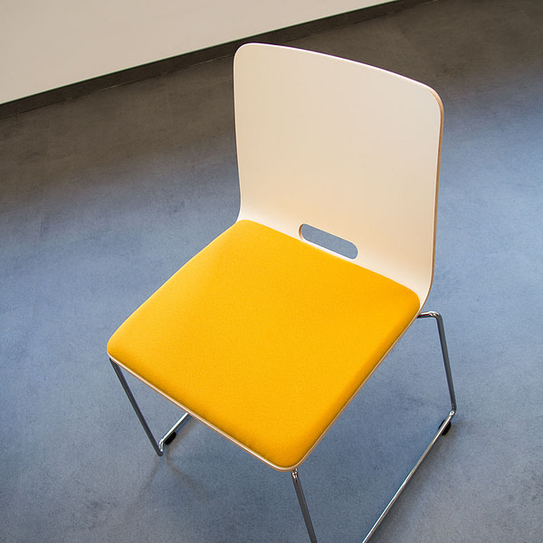 Abbildung von lento Kufenstuhl mit farbigem Sitz zum Einsatz in Firmen Kantinen, Cafes oder Sozialraum