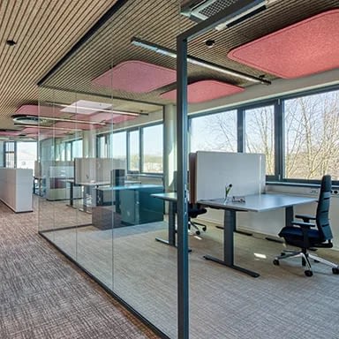 Zwei Arbeitsplätze mit Büroeinrichtung von lento, ausgestattet mit höhenverstellbaren Schreibtischen, Bürostühlen agilis Matrix und durch eine Glaswand mit Fenster vom restlichen Bürobereich abgeschirmt