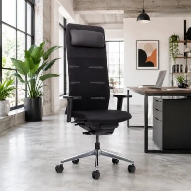 Im Arbeitsbereich steht der agilis matrix Chefsessel mit integrierter Kopfstütze in Schwarz in schräger Rückansicht neben dem Schreibtisch.