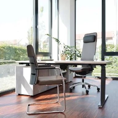 Höhenverstellbarer Schreibtisch elektrisch im Chefzimmer mit braunem Echtleder-Chefsessel und Freischwinger in moderner Büroeinrichtung, Steh-Sitz-Schreibtisch made in Germany, lento