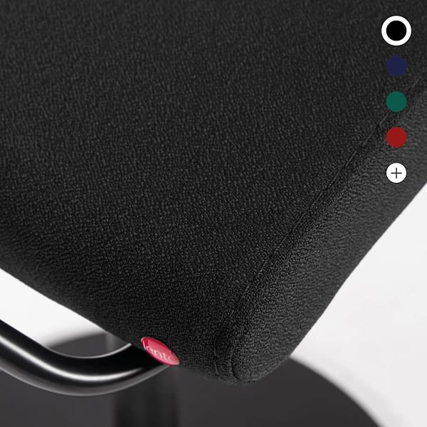 Im Materialdetail ist der schwarze Stoffbezug des Stehhockers sella activa mit sichtbarer Oberflächenstruktur zu sehen.