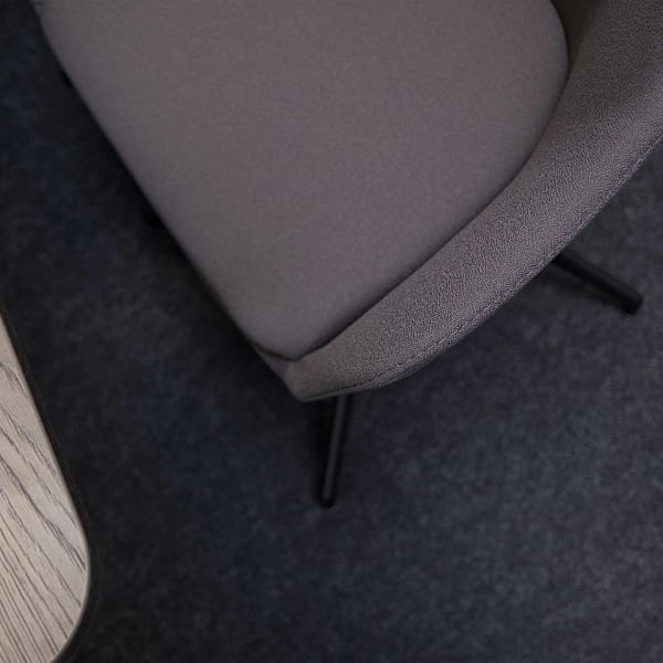 Nahaufnahme eines Konferenzstuhls als Esszimmerstuhl mit braunem Stoffvollpolster, Fokus auf Bezug und sichtbarer Naht von lento