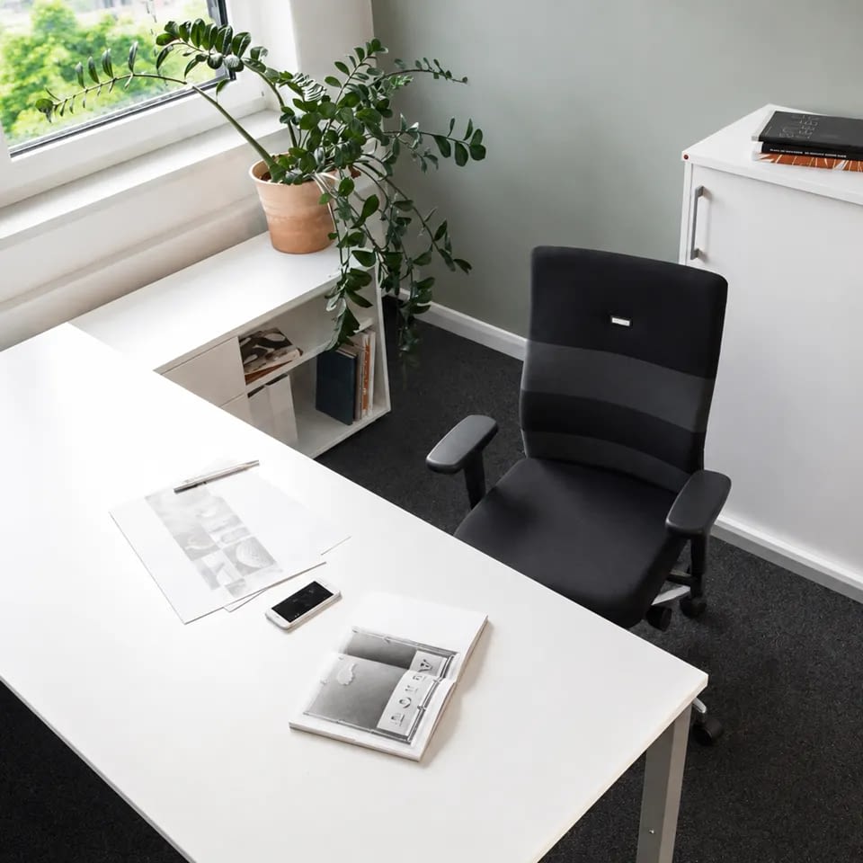Die Aufnahme von oben zeigt den ergonomischen Bürostuhl agilis comfort in Schwarz-Grau neben einem Schreibtisch.