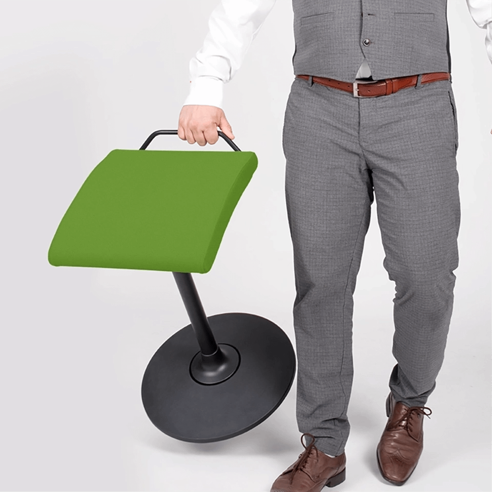 Der Stehhocker sella activa in grün wird von einer Person getragen und beim Transport gezeigt.