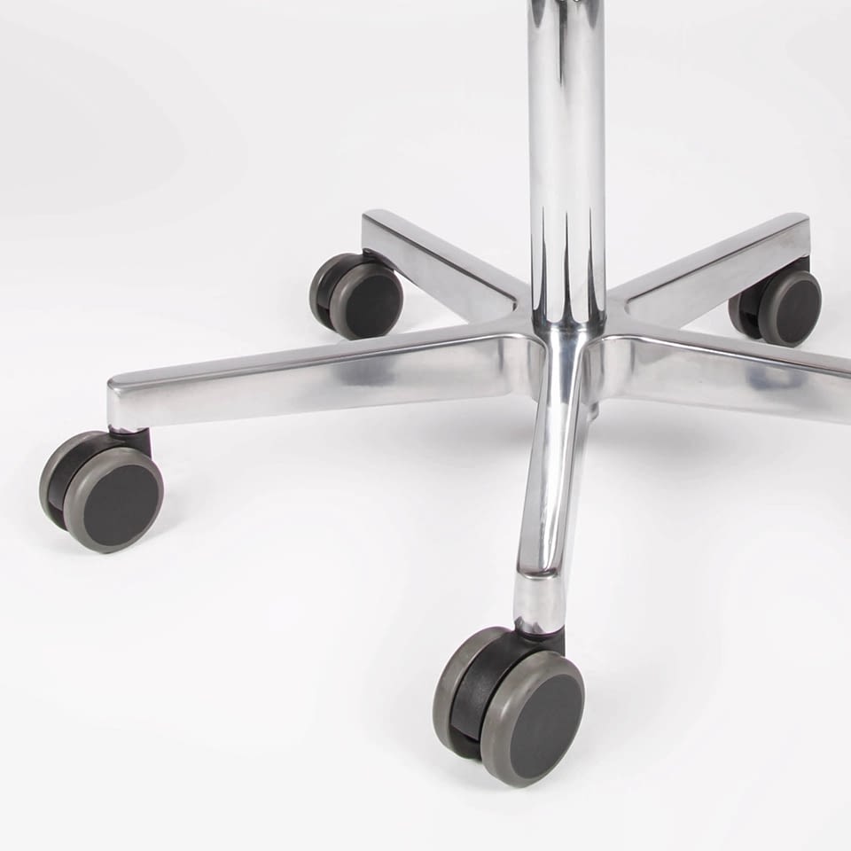 Das Aluminium-Fußkreuz des sella Sattelhockers ist in der Detailaufnahme mit Rollen zu sehen und zeigt Stabilität und Mobilität.