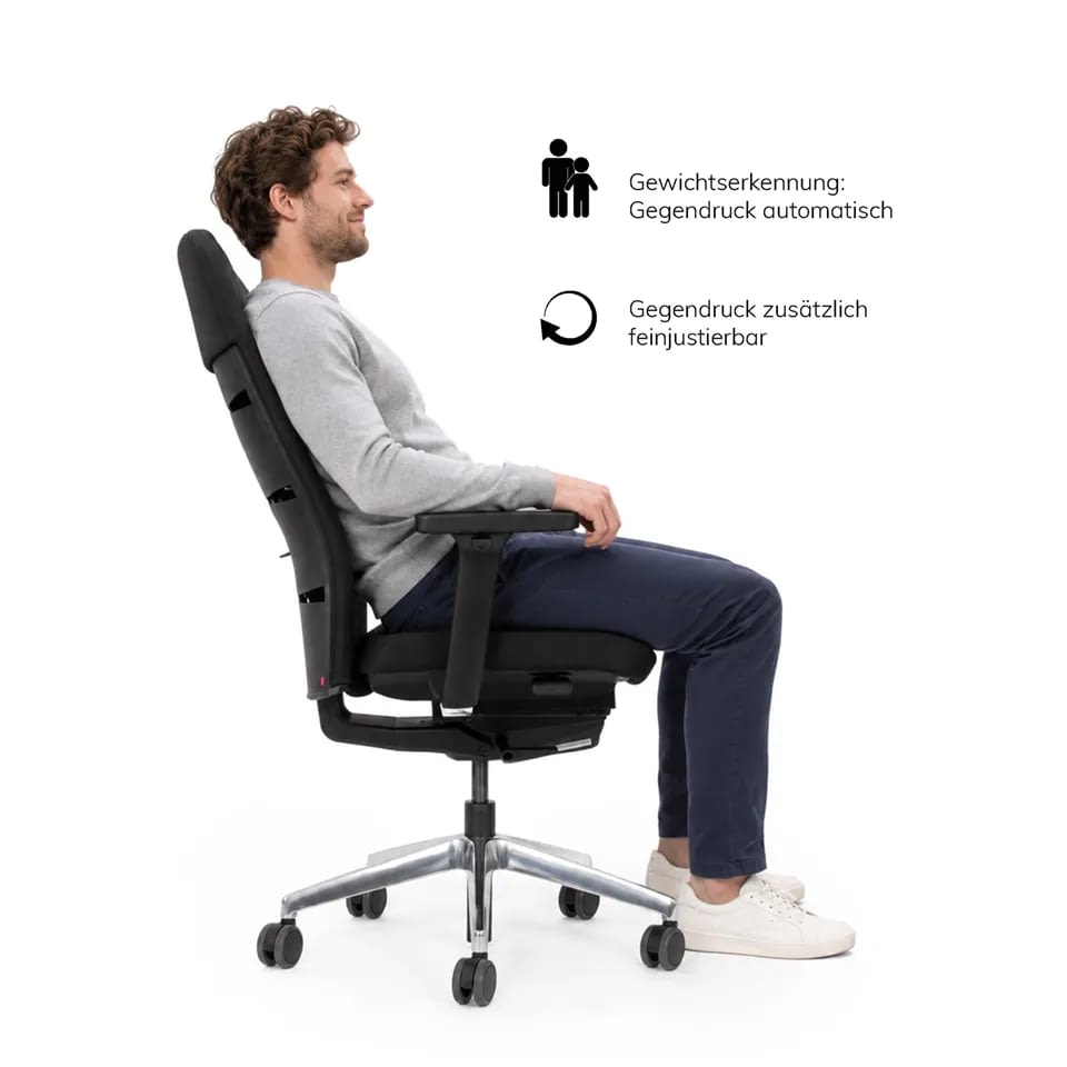 In Seitenansicht sitzt eine Person im ergonomischen Bürostuhl agilis matrix comfort in schwarz mit Netzrücken.