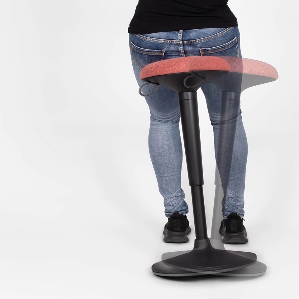 Eine Person ist auf dem Stehhocker sella flex in Bewegung zu sehen.