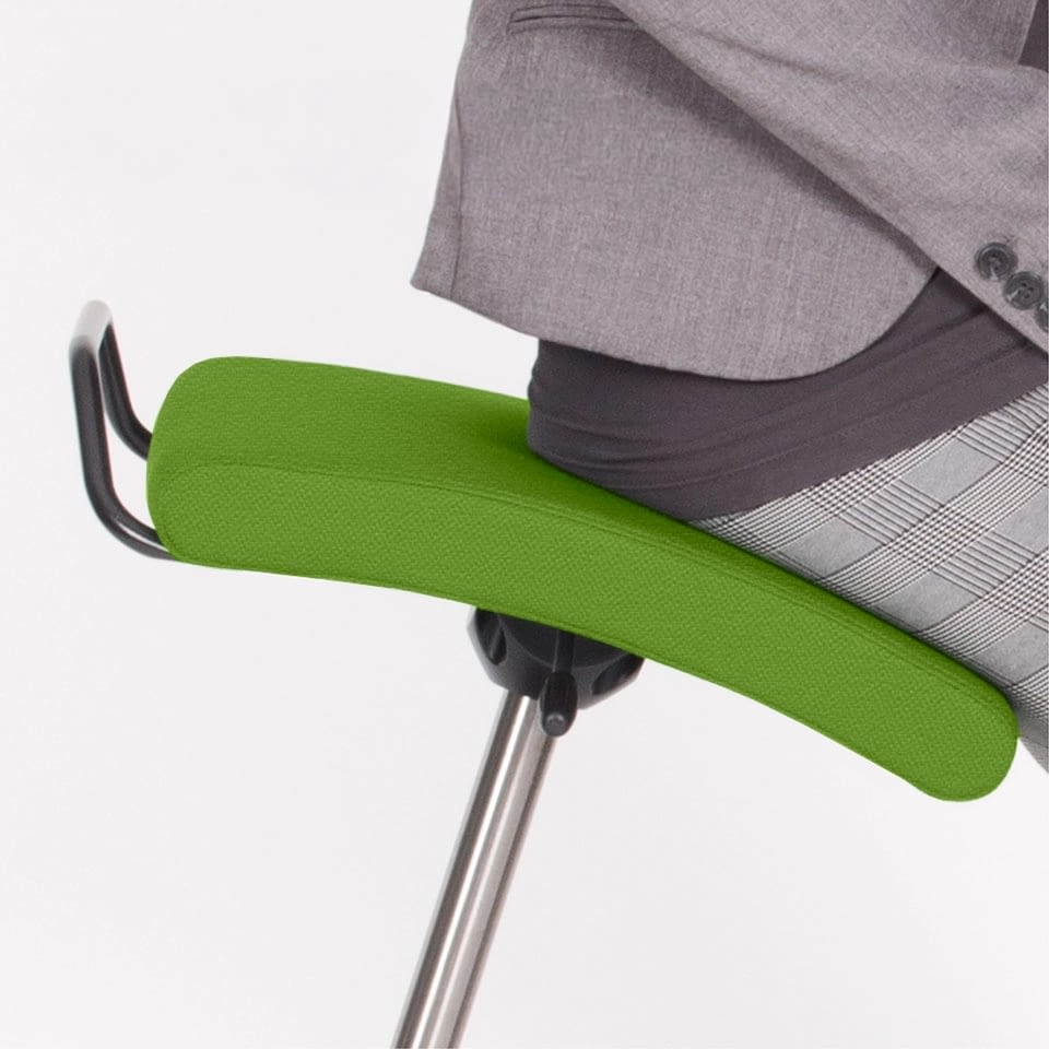In der Detailaufnahme ist der grüne Stehhocker sella activa mit einer sitzenden Person abgebildet.
