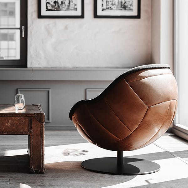 Bild eines Loungesessels in Retrodesign und Echtleder braun vor Fenster in einer privaten Lounge